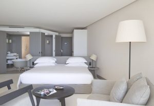 Chambre meublée d'un lit king size, d'une télévision et de fauteuils confortables